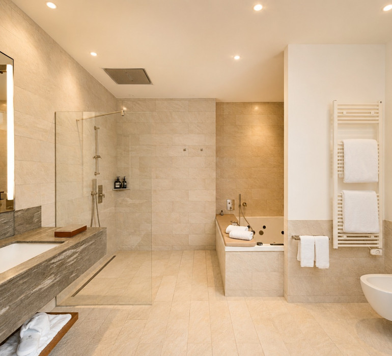 Grosszügiges Badezimmer mit Jacuzzi-Badewanne und Regendusche.