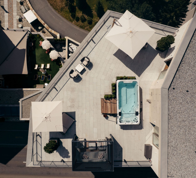 GRACE Penthouse terrace with a large pool and views of the lake and mountains in St. Moritz.