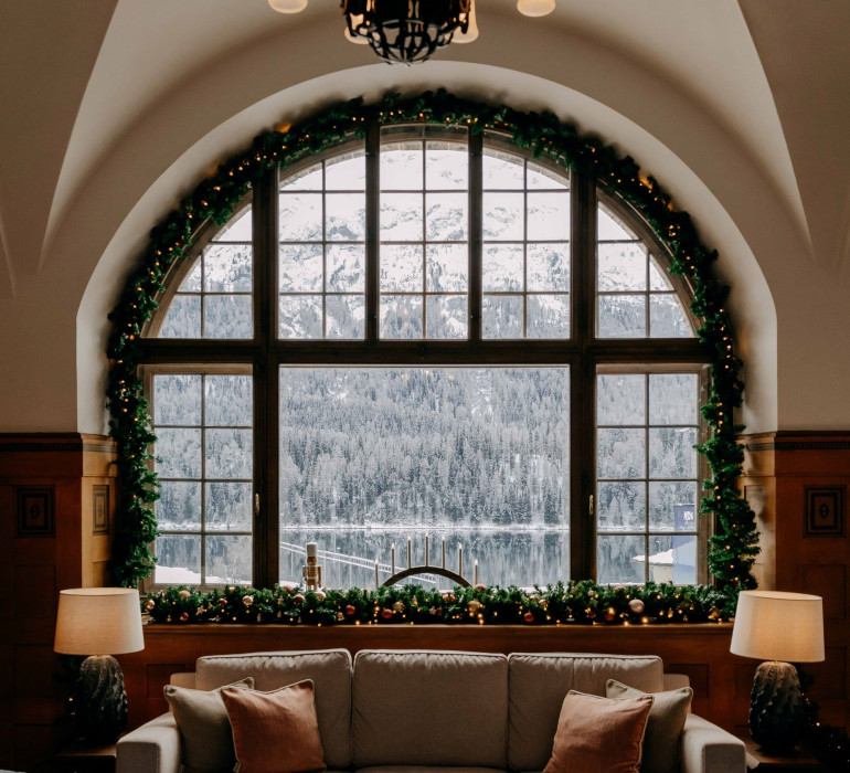 Großzügiger Wohnzimmer Bereich mit Kaminfeuer, Teesorten, großem Fenster mit Blick auf den See.